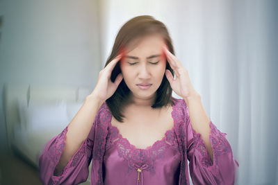 Woman in nightie massaging head