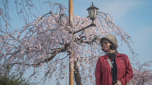 Portrait of young man standing on tree