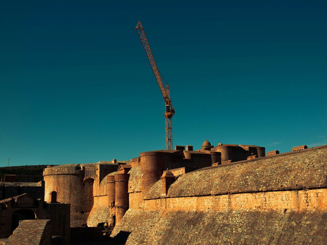 clear sky, built structure, architecture, building exterior, copy space, low angle view, blue, construction site, sunlight, outdoors, day, construction, no people, old, house, building, residential structure, development, shadow, industry