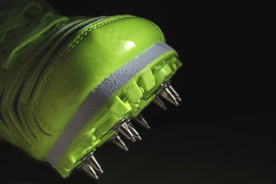 Close-up of green tomato over black background