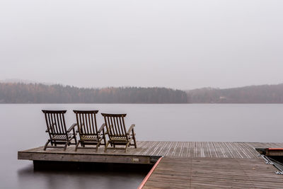 Deck chairs on jetty overlooking calm lake