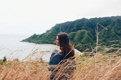 Woman by sea against clear sky