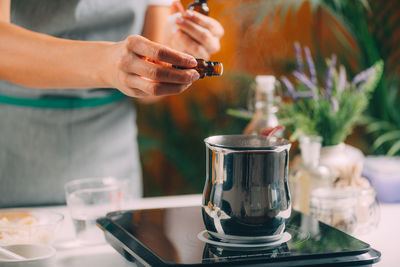 Woman preparing homemade soap with essential oil extracts