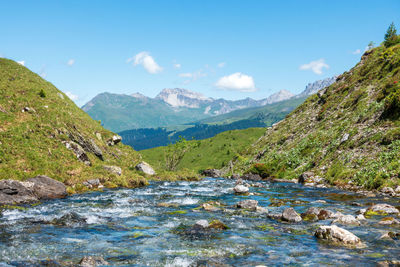 Scenic view of river amidst mountains against sky