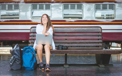 Full length of woman sitting on bench