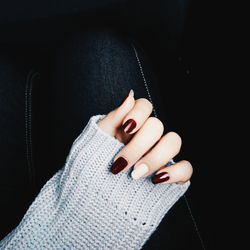 Cropped hand with nail polish on fingernails