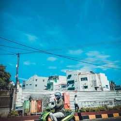 Man working on building against blue sky