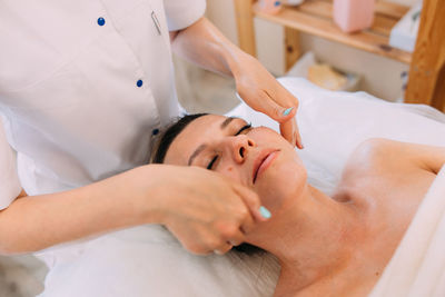 Cosmetologist does facial massage for woman. beauty skin care