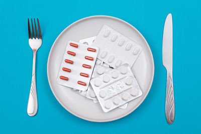 High angle view of glasses on table against blue background