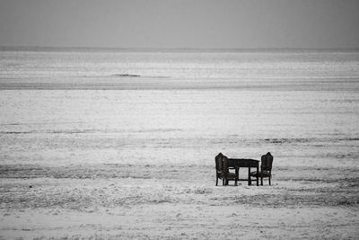 Chair on beach against sky