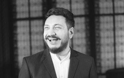 Smiling bearded man standing indoors