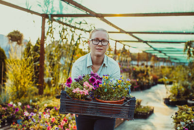 Portrait of beautiful woman standing in greenhouse