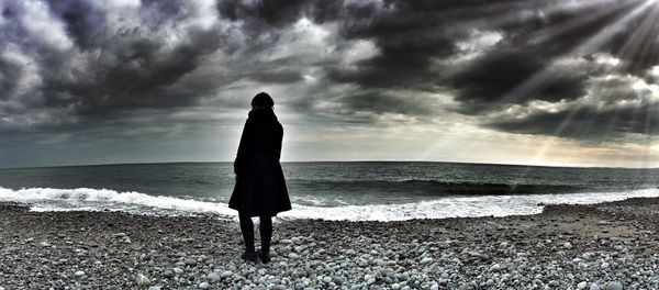 Scenic view of beach against cloudy sky