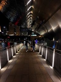 Rear view of woman in illuminated underground at night