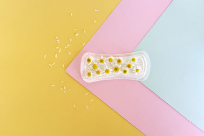 A sanitary pad with chamomile flowers lies on a colorful background. menstruation days