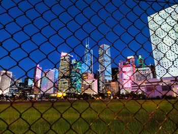View of buildings seen through chainlink fence