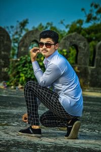 Portrait of young man wearing sunglasses standing outdoors