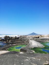 Scenic view of land against clear blue sky