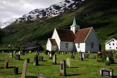 Cemetery in front of an old church with green snow-capped mountain in the background