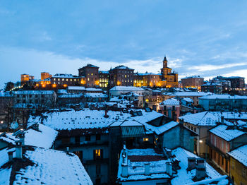 Illuminated city against sky during winter