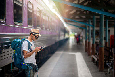 Man using mobile phone while standing on bus