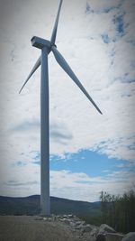 Windmills on landscape against sky