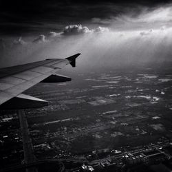 Cropped image of airplane flying over clouds