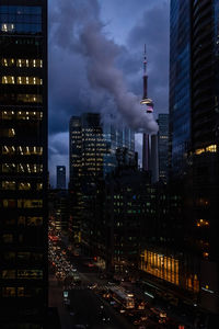 Illuminated buildings in city against sky at night