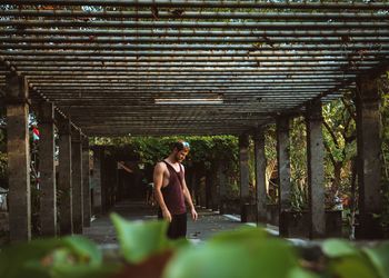 Full length of shirtless man standing against wall