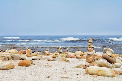 Rocks on beach against clear sky