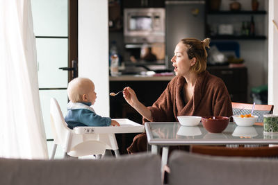 Young woman using laptop while sitting on table