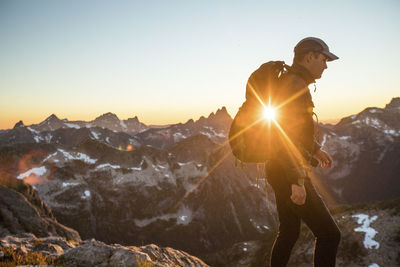 Side view of backpacker hiking through the mountains.