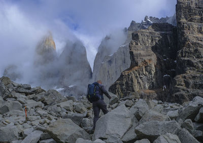 Panoramic view of man walking on rocks against mountains