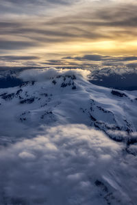 Scenic view of snow covered mountains against sky during sunset