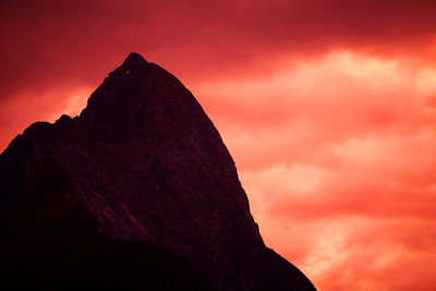 Low angle view of silhouette rocks against orange sky