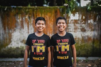PORTRAIT OF HAPPY YOUNG COUPLE STANDING IN WATER