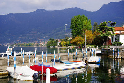 Sailboats moored on lake against sky