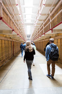 Rear view of people walking in corridor of building