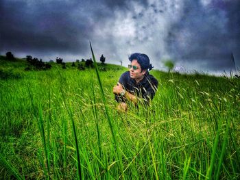 Full length of man photographing on field against sky