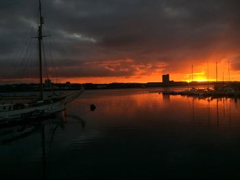 Scenic view of sea against cloudy sky at sunset