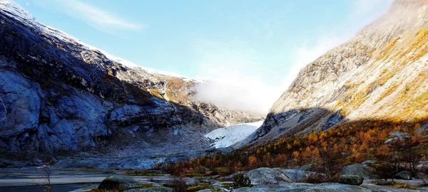 Scenic view of lake by mountains against sky