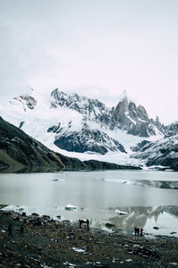 Glacial lake with snowcapped mountains in the background in winter