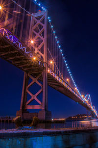 Low angle view of suspension bridge at night