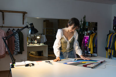 Young designer woman dressmaker work on new clothes collection in studio workshop. small business.