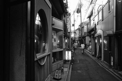 Illuminated street amidst buildings in city