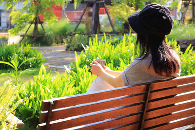 Rear view of woman with plants in foreground