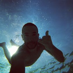 Portrait of shirtless man swimming in sea