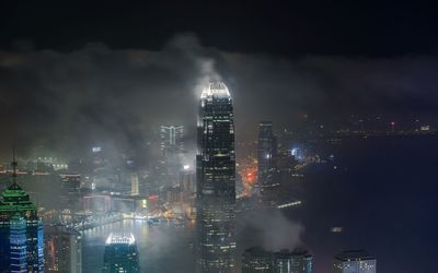 Illuminated buildings in city against sky at night