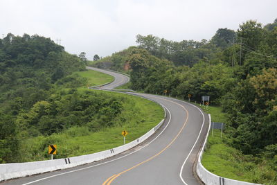 Road amidst trees against sky