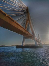 Suspension bridge over sea against sky